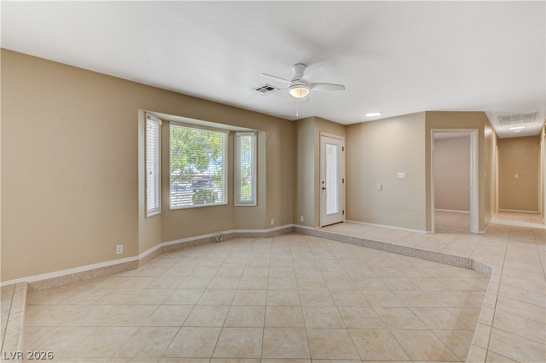 7631 Bermuda Road Las Vegas, NV 89123 - Photo 10 of 64 A spacious living area features elegant tiled flooring and a bright bay window.