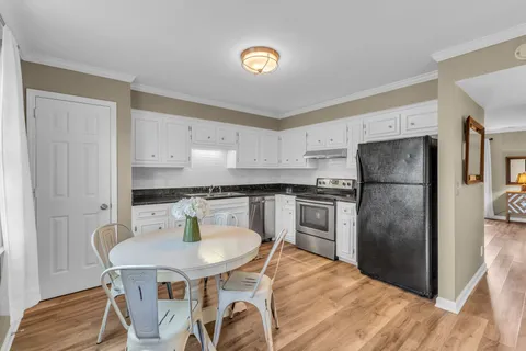 a kitchen with stainless steel appliances kitchen island granite countertop a refrigerator a stove a sink dishwasher with a dining table and chairs