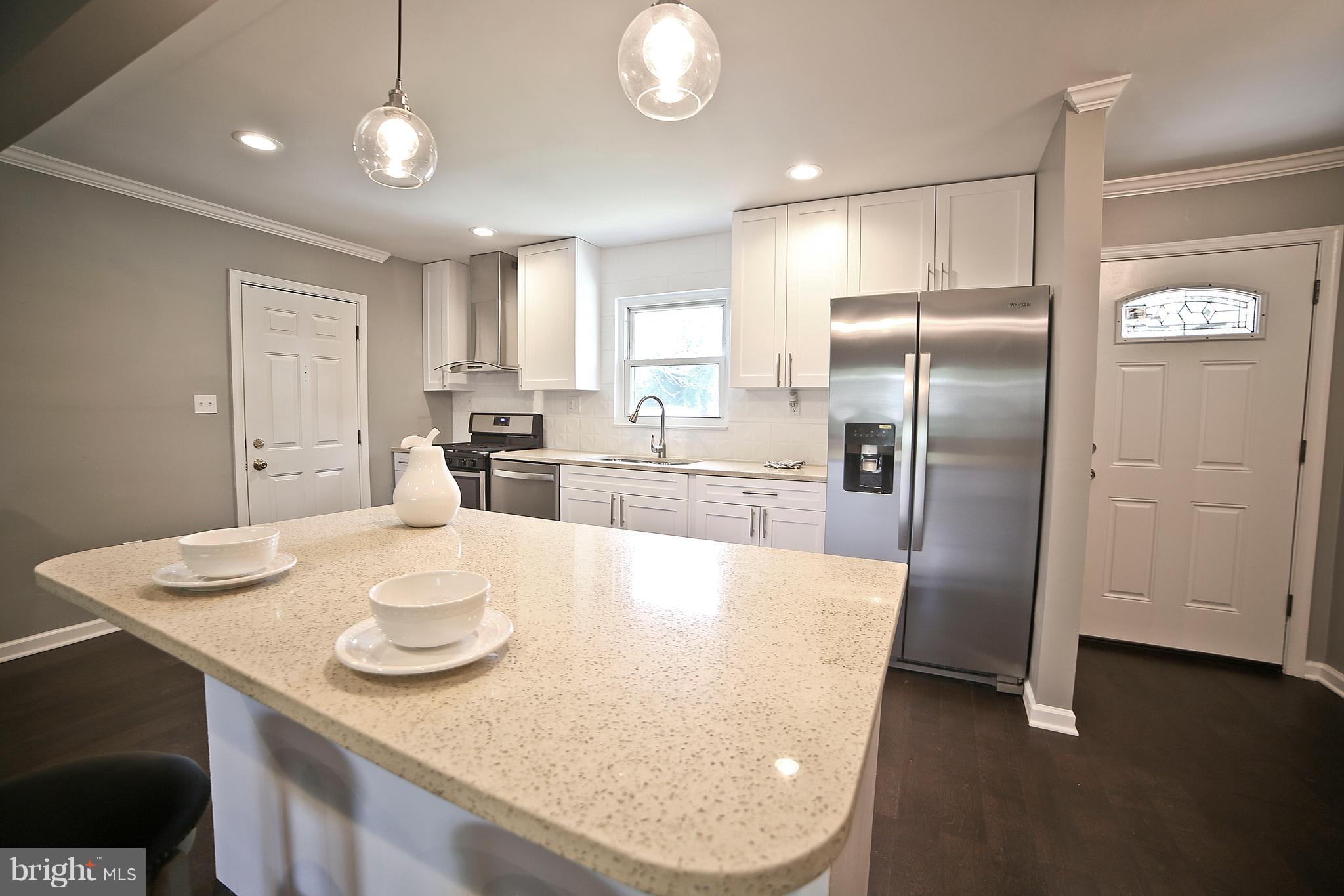 6612 Cimarron Street Springfield, VA 22150 - Photo 12 of 30 a kitchen with stainless steel appliances granite countertop a sink a refrigerator and a dining table