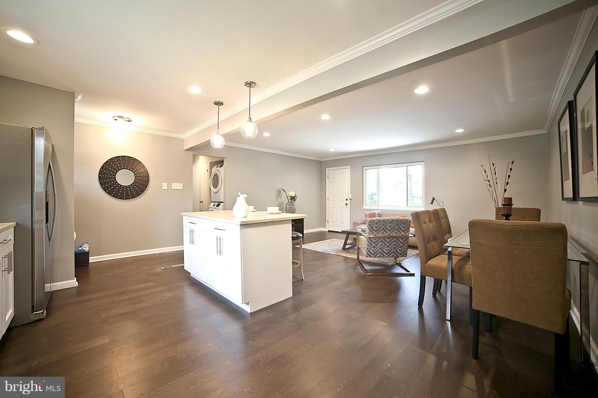 6612 Cimarron Street Springfield, VA 22150 - Photo 13 of 30 a living room with furniture a wooden floor and a kitchen