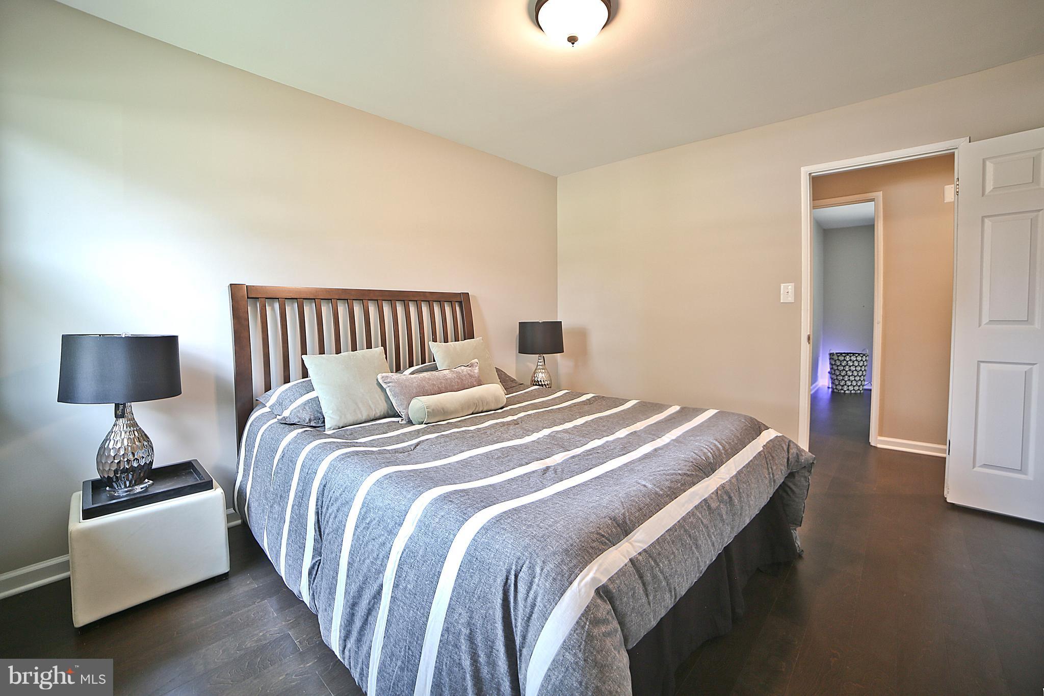 6612 Cimarron Street Springfield, VA 22150 - Photo 18 of 30 a bedroom with a bed and a lamp