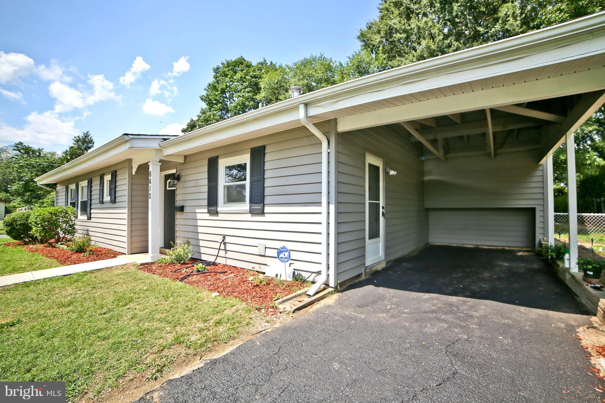 6612 Cimarron Street Springfield, VA 22150 - Photo 26 of 30 a front view of a house with a yard and garage