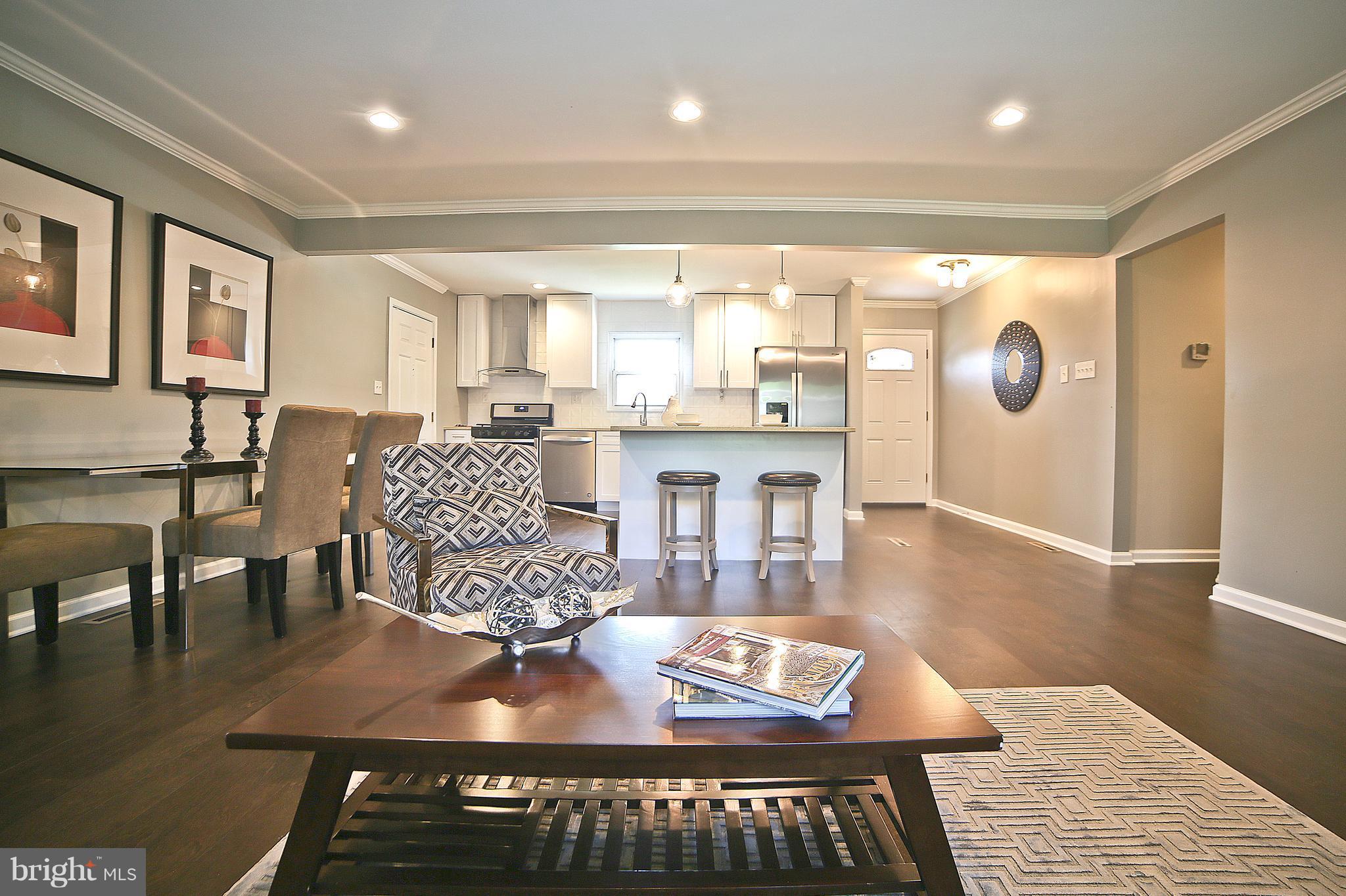 6612 Cimarron Street Springfield, VA 22150 - Photo 5 of 30 a living room with kitchen island granite countertop furniture and a wooden floor