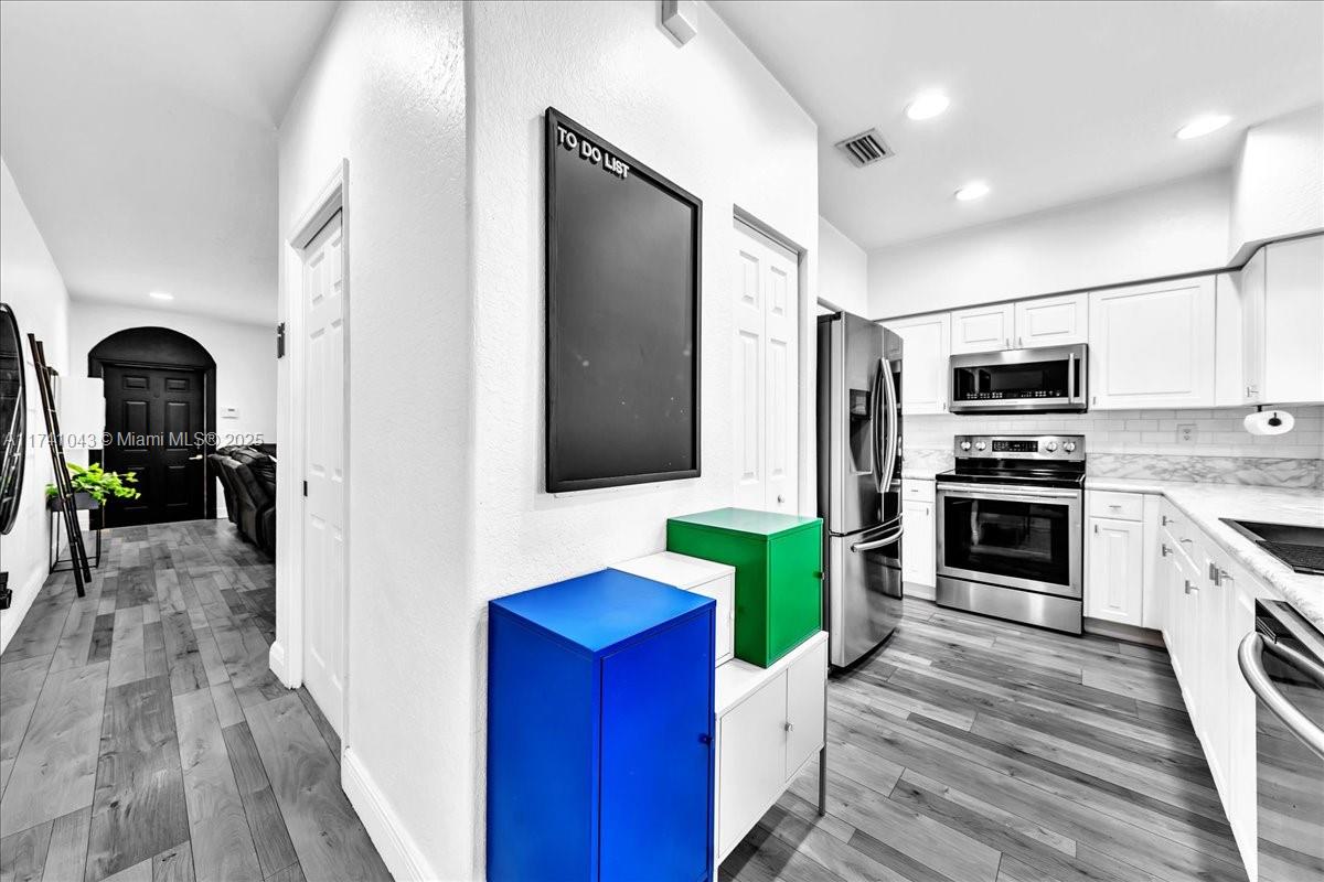 8381 Southwest 26 Th Street, Unit 103 Miramar, FL 33025 - Photo 12 of 62 a kitchen with stainless steel appliances a refrigerator and a stove top oven