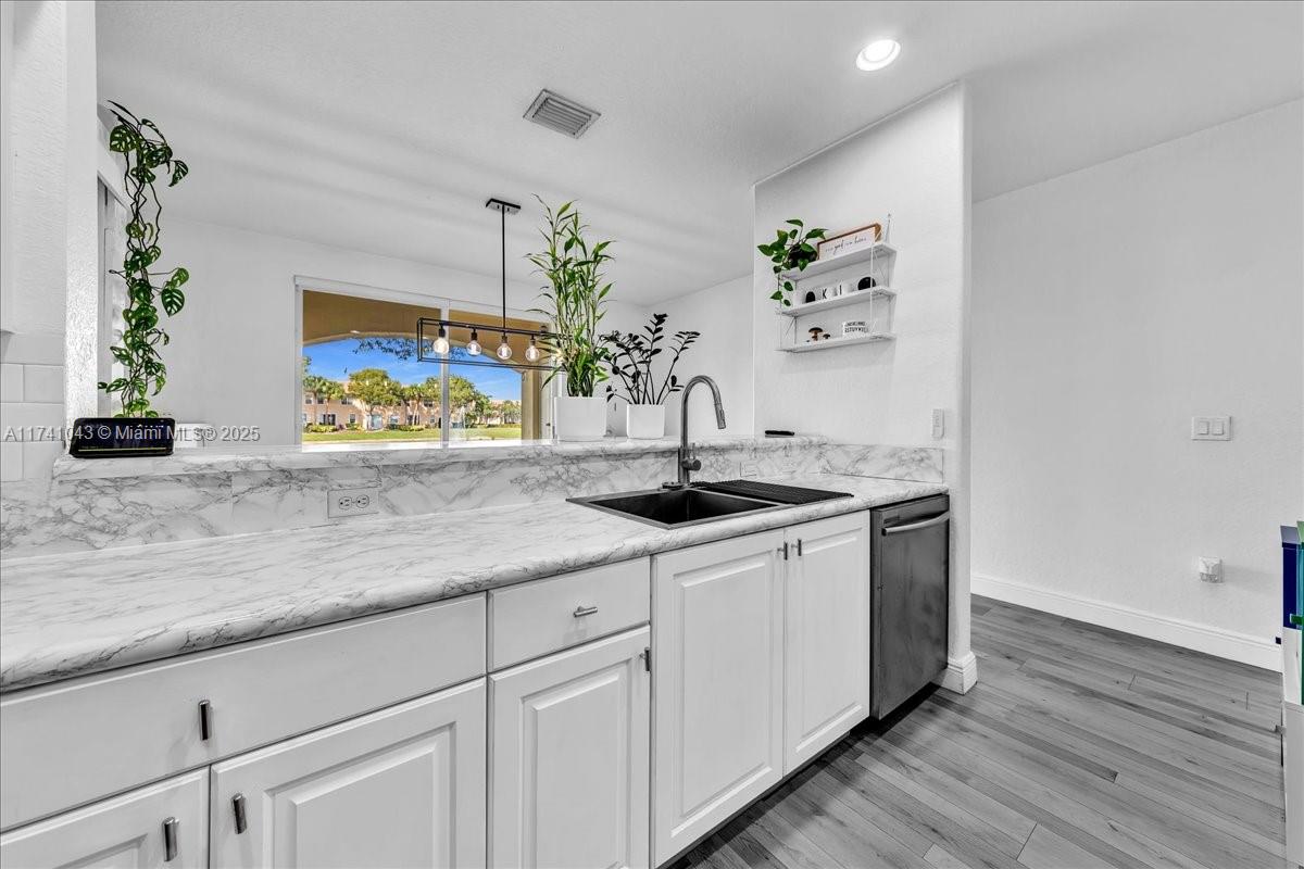 8381 Southwest 26 Th Street, Unit 103 Miramar, FL 33025 - Photo 18 of 62 a kitchen with stainless steel appliances a sink and a potted plant