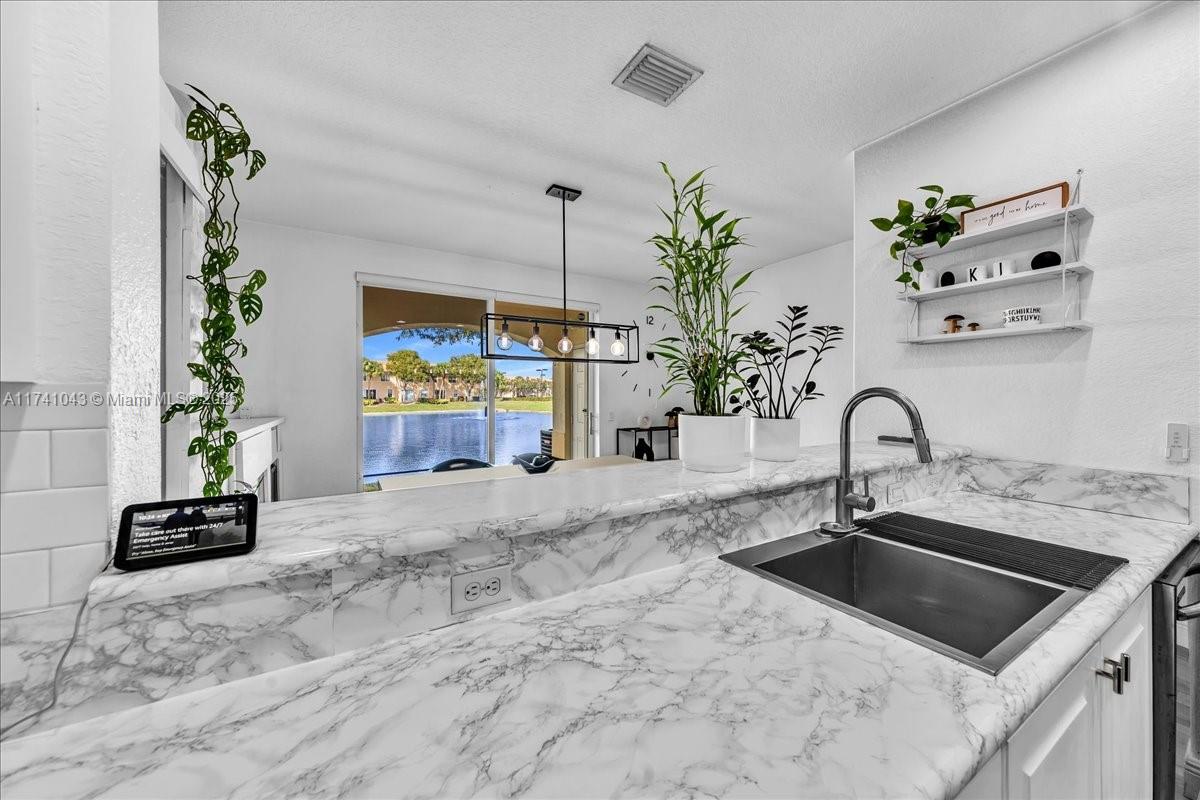 8381 Southwest 26 Th Street, Unit 103 Miramar, FL 33025 - Photo 19 of 62 a kitchen with a sink and a stove top oven