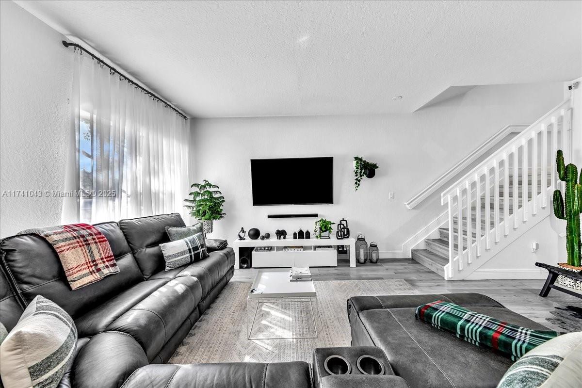 8381 Southwest 26 Th Street, Unit 103 Miramar, FL 33025 - Photo 4 of 62 a living room with furniture and a flat screen tv