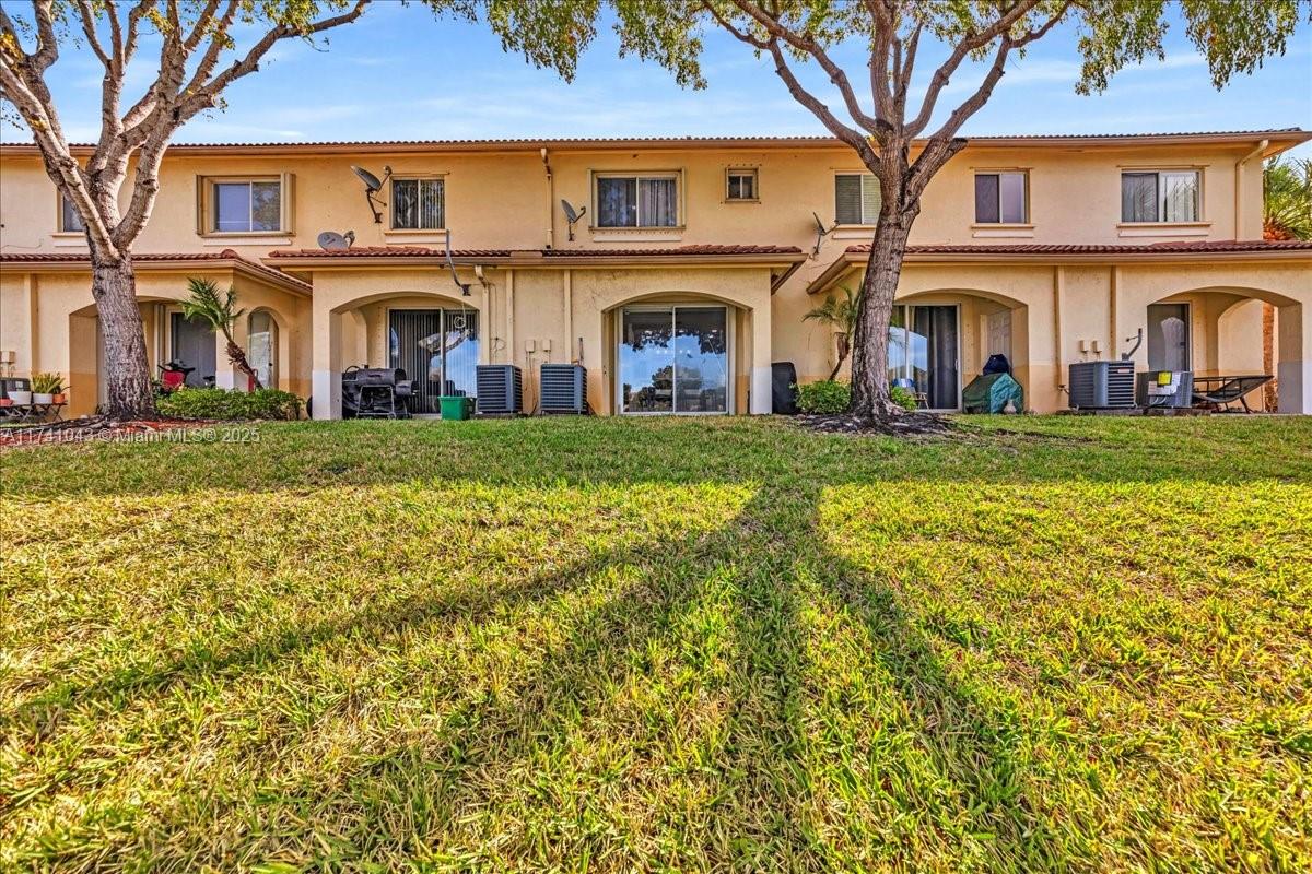 8381 Southwest 26 Th Street, Unit 103 Miramar, FL 33025 - Photo 47 of 62 a view of a big house with a big yard and large trees