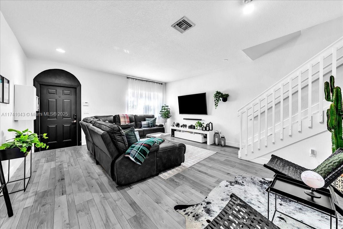 8381 Southwest 26 Th Street, Unit 103 Miramar, FL 33025 - Photo 7 of 62 a living room with furniture and a flat screen tv