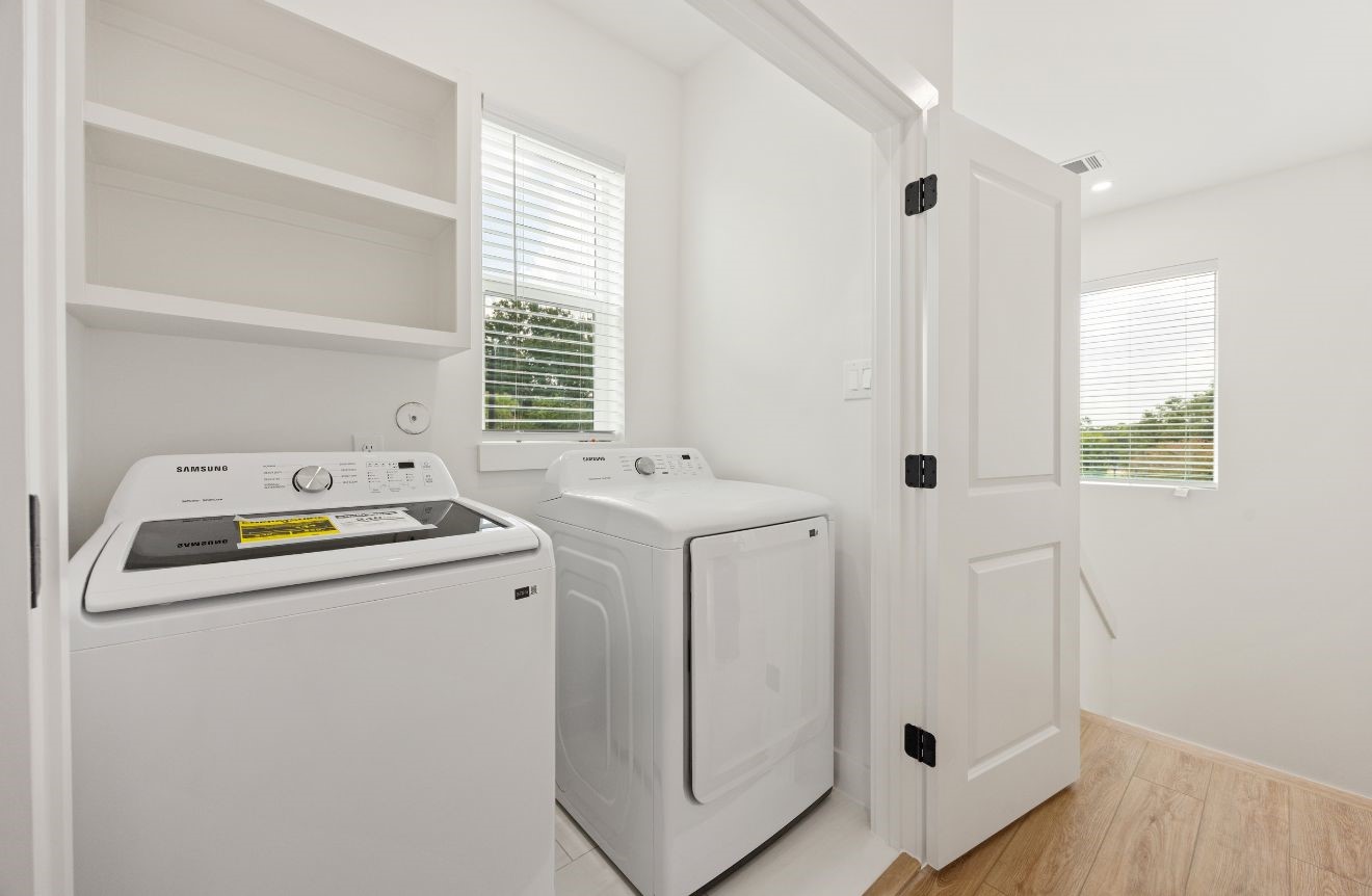 2121 Hoskins Drive, Unit C Houston, TX 77080 - Photo 22 of 34 Convenient in-home utility room with Samsung washer and dryer, built-in upper shelving, bright window, and clean white finishes. Positioned near the main living level, this laundry space offers practical function, natural light, and easy access while maintaining the home’s modern, streamlined design.