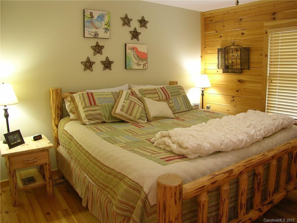 145 Spring Hill Ln Mill Spring, Unit 32 Mill Spring, NC 28756 - Photo 11 of 24 a bedroom with a bed and wall painting