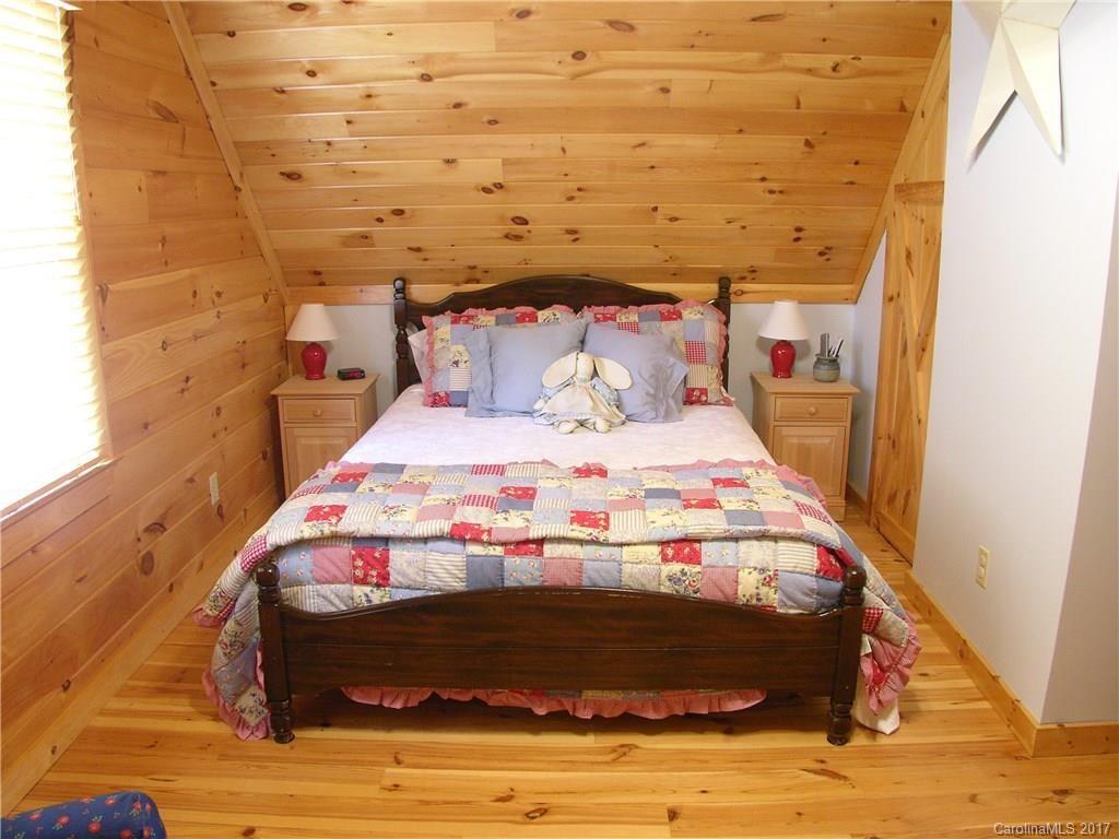 145 Spring Hill Ln Mill Spring, Unit 32 Mill Spring, NC 28756 - Photo 18 of 24 a bed sitting in a bedroom next to a wall