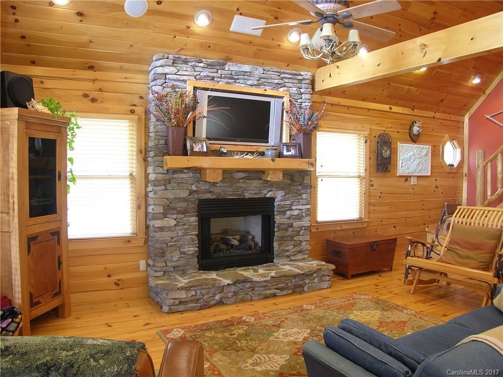 145 Spring Hill Ln Mill Spring, Unit 32 Mill Spring, NC 28756 - Photo 3 of 24 a living room with furniture a flat screen tv and a fireplace