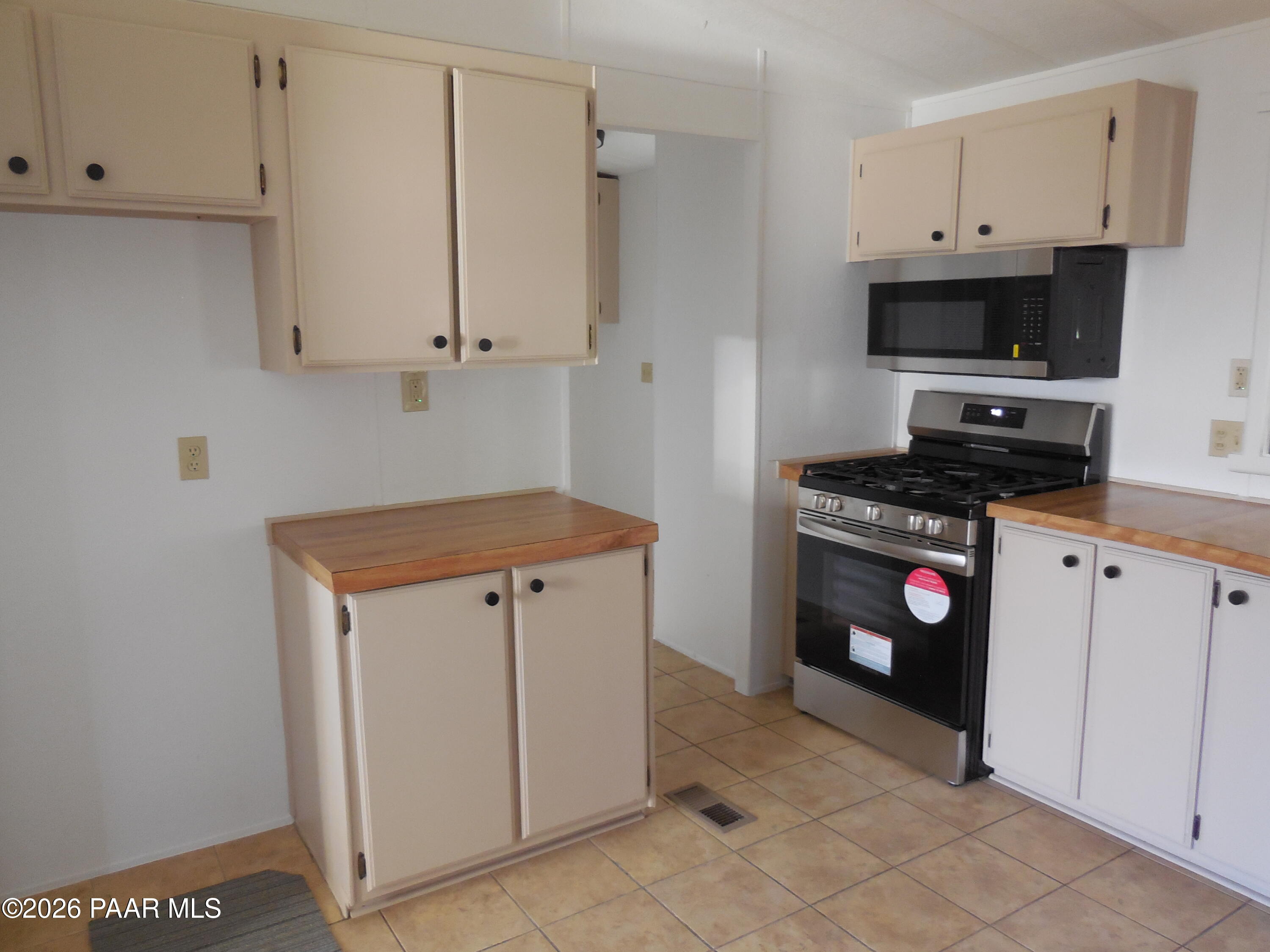 1145 Trinity Court Prescott, AZ 86301 - Photo 12 of 23 a kitchen with stainless steel appliances a stove a microwave a sink and cabinets