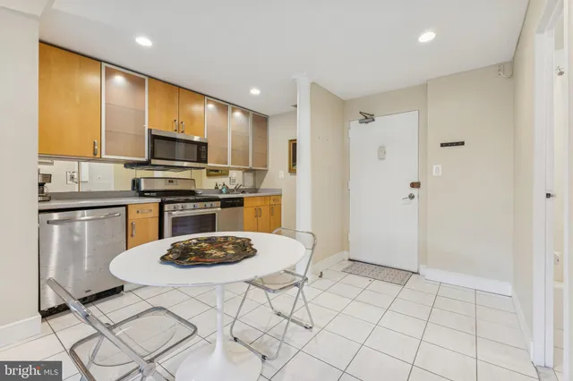 a kitchen with stainless steel appliances a stove a sink a microwave a refrigerator and cabinets