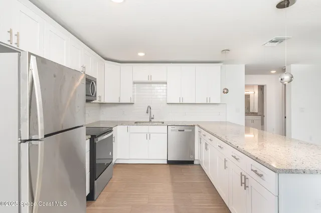 a kitchen with granite countertop a refrigerator and a sink