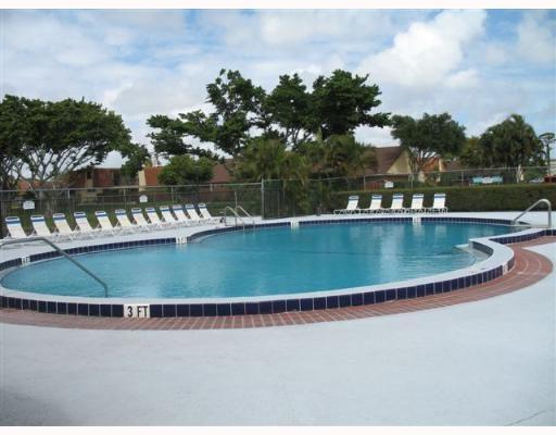 601 Springdale Circle Palm Springs, FL 33461 - Photo 13 of 14 a view of a swimming pool with outdoor seating