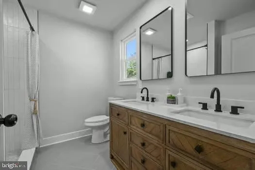 a bathroom with a granite countertop sink a toilet and a mirror