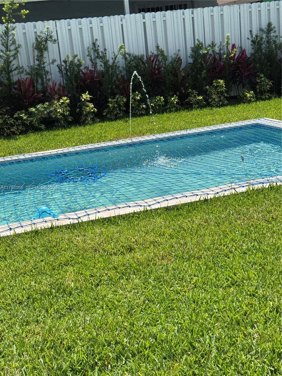 910 Southwest 24th Road Miami, FL 33129 - Photo 37 of 38 a view of a swimming pool with a yard and a large tree