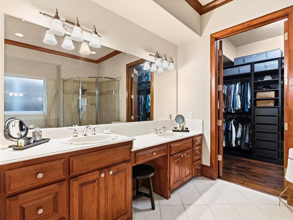 1615 Roma Lane Allen, TX 75013 - Photo 16 of 36 Dual vanities with white countertops, wood-finish cabinetry, and chrome fixtures