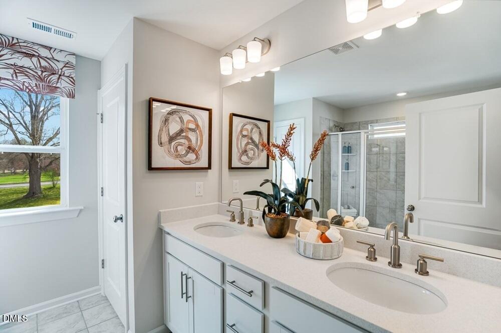 717 Bolera Road Knightdale, NC 27545 - Photo 21 of 43 a bathroom with double vanity sinks a vanity and a mirror