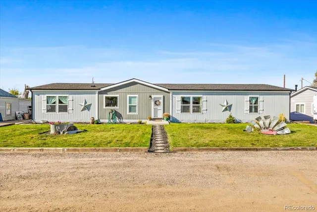 a front view of house with a garden and yard