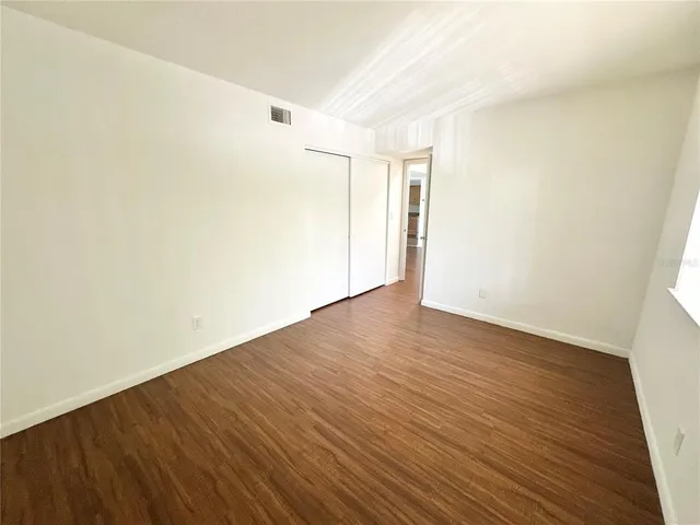 a view of an empty room with wooden floor