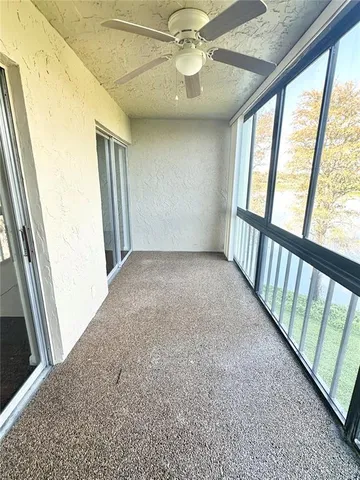 a view of an empty room with floor to ceiling windows and stairs
