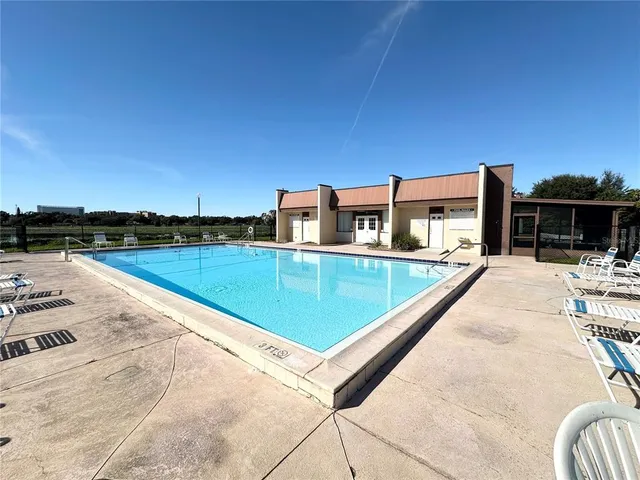 a view of a wooden bench sitting under a large tree
