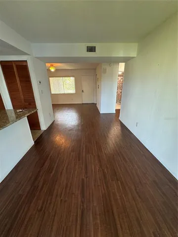 a view of empty room with wooden floor