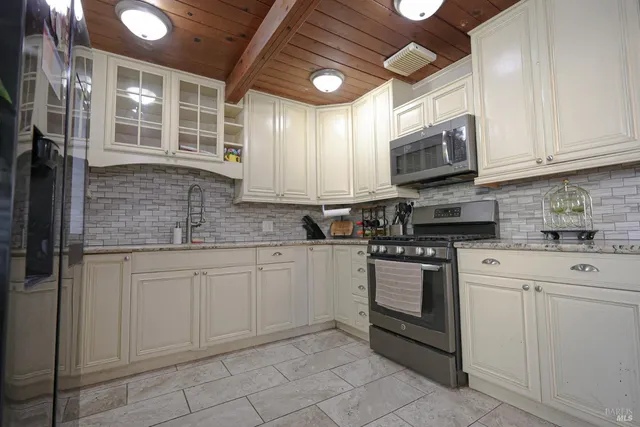 a kitchen with stainless steel appliances granite countertop a refrigerator and a sink
