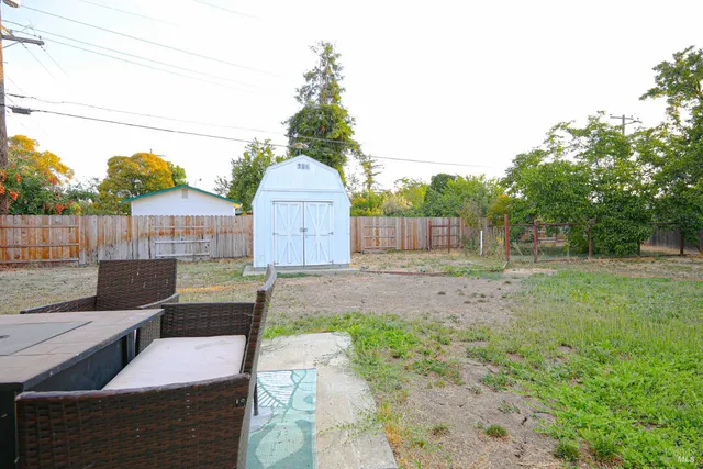 a view of backyard with wooden fence
