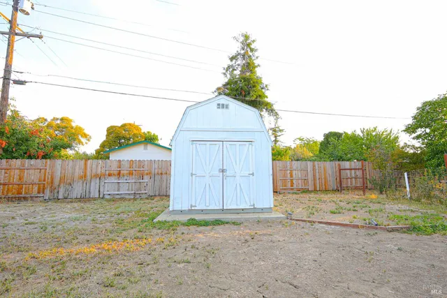 a backyard of a house with table and chairs