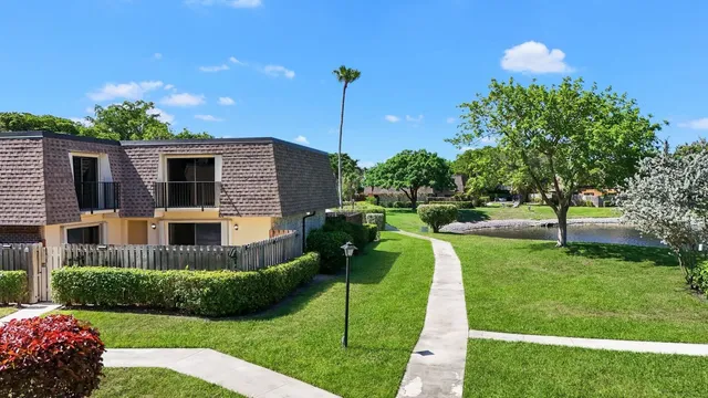 an aerial view of residential houses with outdoor space and trees