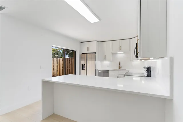 a kitchen with white cabinets and white appliances
