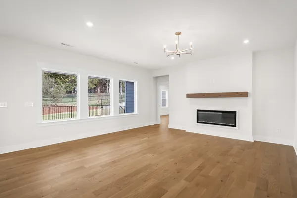a view of an empty room with a fireplace and a window