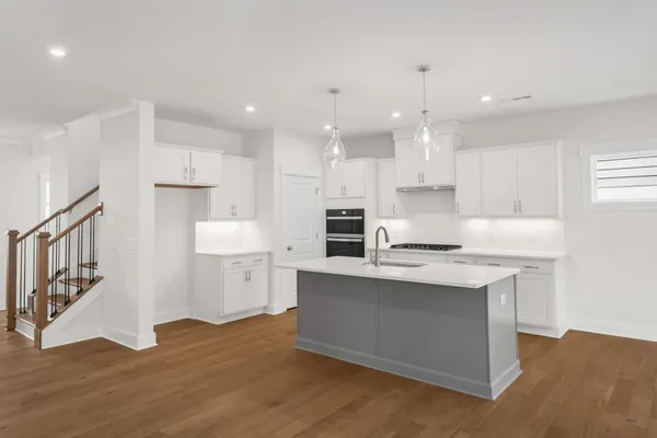 a kitchen with kitchen island a sink stainless steel appliances and cabinets