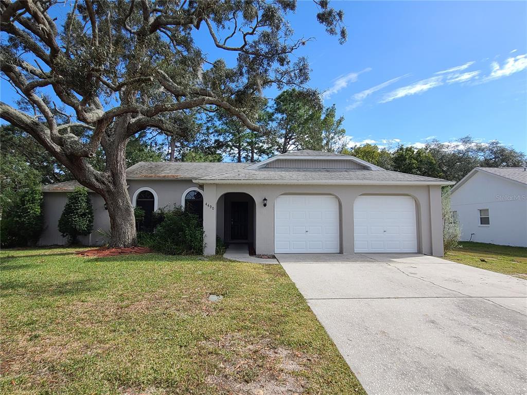 4490 Plumosa Street Spring Hill, FL 34607 - Photo 1 of 1 a front view of a house with a yard and garage