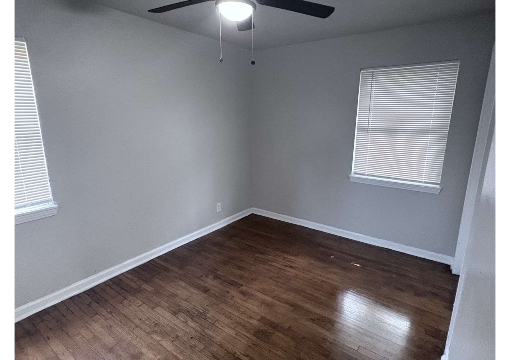 5923 Van Fleet Street Houston, TX 77033 - Photo 16 of 23 an empty room with wooden floor chandelier fan and windows