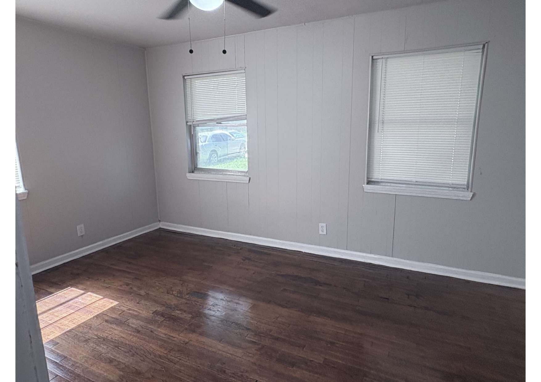 5923 Van Fleet Street Houston, TX 77033 - Photo 22 of 23 an empty room with wooden floor chandelier fan and windows