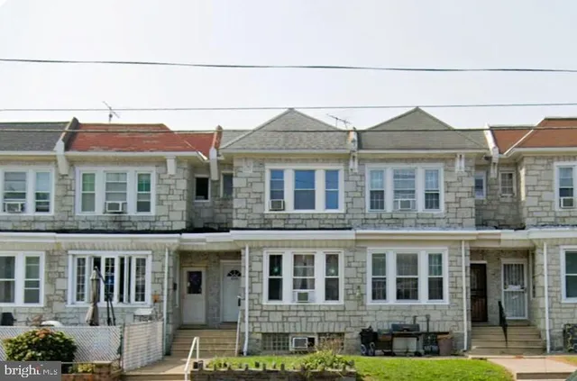 a front view of a residential apartment building with a yard