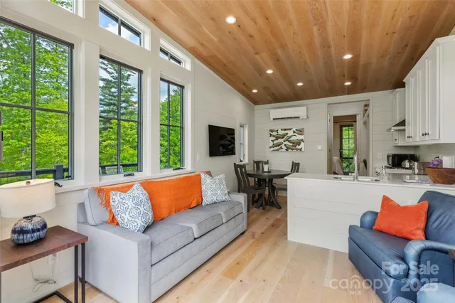 a living room with furniture flat screen tv and a large window