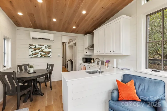 a kitchen with stainless steel appliances kitchen island granite countertop furniture a refrigerator a sink a dining table and chairs