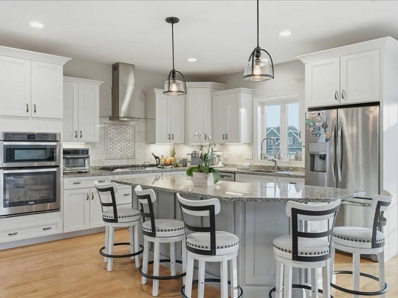 2 Aspen Drive Pelham, NH 03076 - Photo 11 of 42 a kitchen with stainless steel appliances kitchen island granite countertop a table chairs stove and microwave
