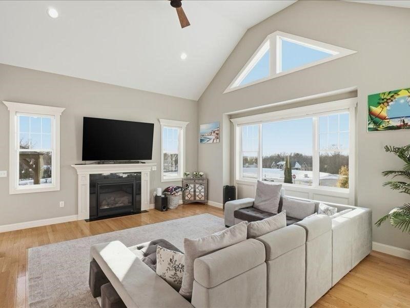 2 Aspen Drive Pelham, NH 03076 - Photo 20 of 42 a living room with furniture a fireplace and a flat screen tv