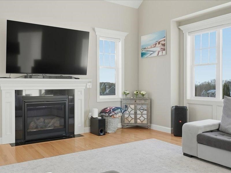2 Aspen Drive Pelham, NH 03076 - Photo 21 of 42 a living room with furniture a flat screen tv and a fireplace