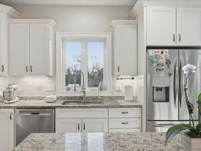 2 Aspen Drive Pelham, NH 03076 - Photo 7 of 42 a kitchen with stainless steel appliances kitchen island granite countertop a refrigerator and cabinets