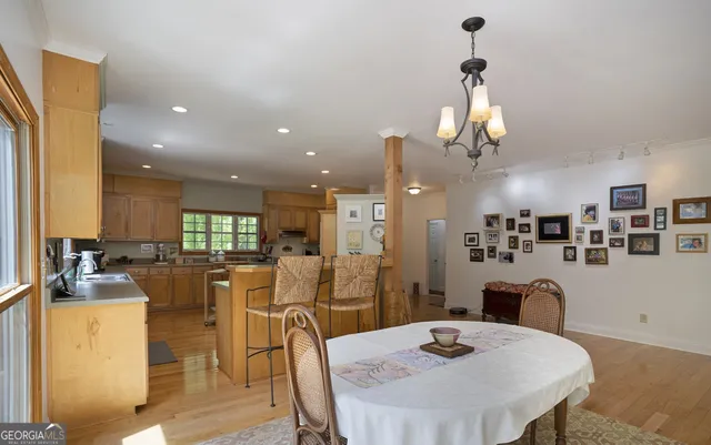 a view of a dining room and livingroom with furniture wooden floor a chandelier