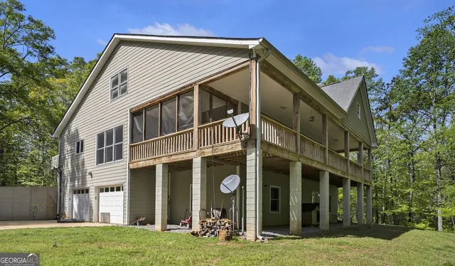 an aerial view of residential houses with outdoor space and trees