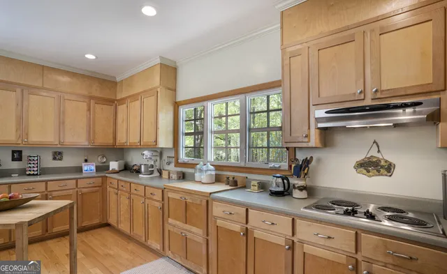a kitchen with a sink a counter top space a large window and stainless steel appliances